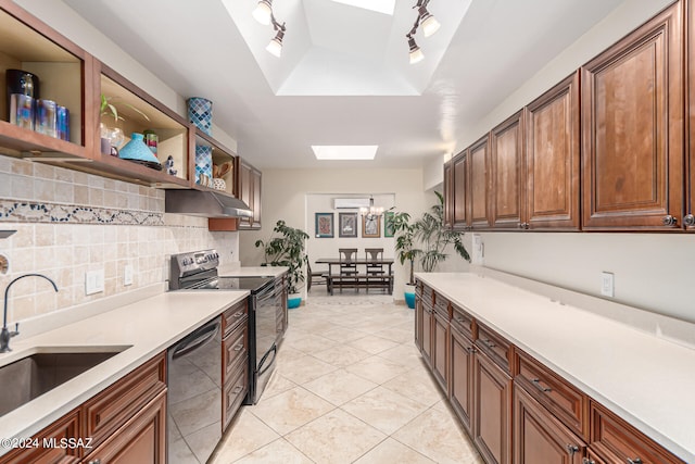 kitchen with light tile patterned flooring, sink, decorative backsplash, a skylight, and appliances with stainless steel finishes