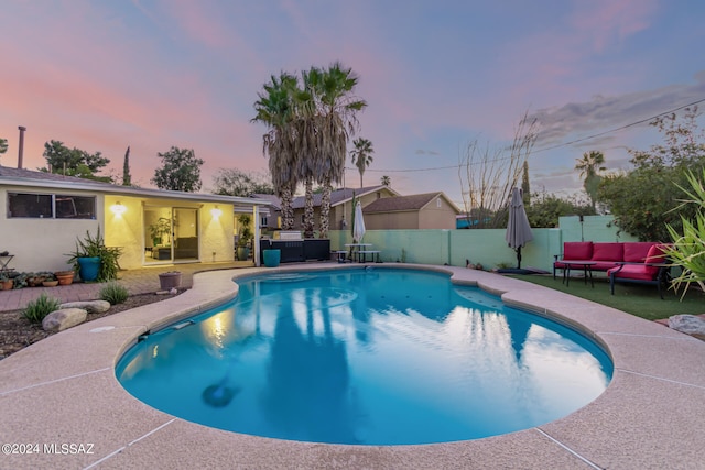 pool at dusk featuring a patio area