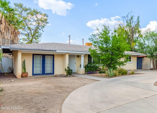 5731 E 2nd St, Tucson, AZ 85711 - ranch-style home featuring stucco siding, roof with shingles, and french doors