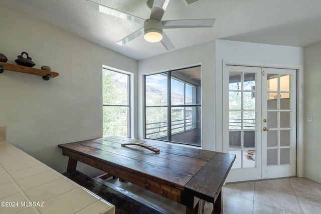 tiled dining area featuring ceiling fan and french doors