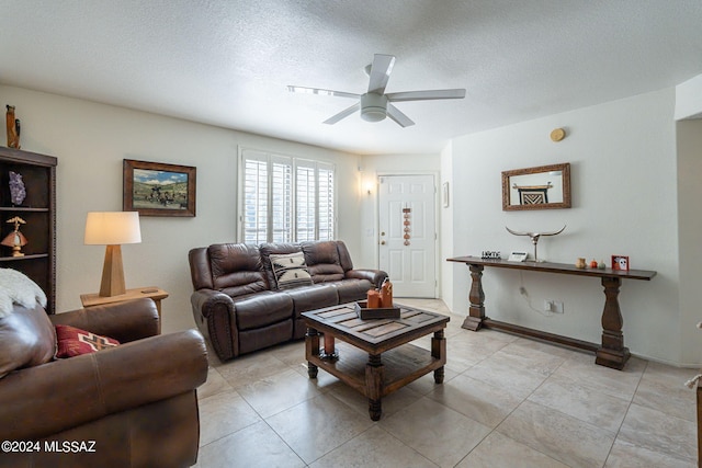 tiled living room with a textured ceiling and ceiling fan