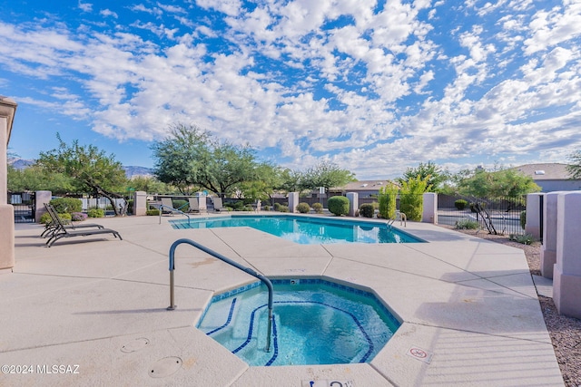 view of swimming pool with a hot tub and a patio area