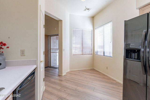 kitchen featuring stainless steel refrigerator with ice dispenser, dishwasher, and light wood-type flooring