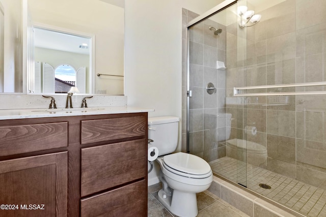 bathroom with tile patterned floors, a shower with door, vanity, and toilet