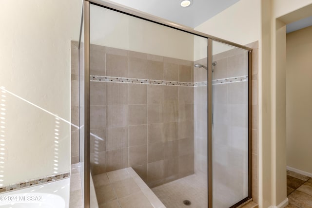 bathroom with tile patterned flooring and walk in shower