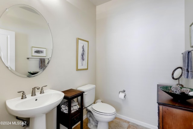 bathroom featuring sink, tile patterned flooring, and toilet