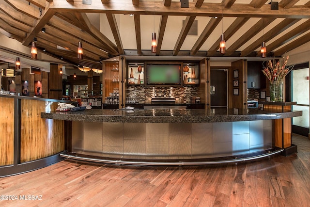 bar featuring hardwood / wood-style floors, vaulted ceiling with beams, and decorative backsplash