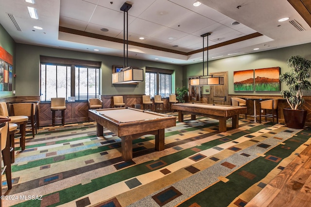 recreation room featuring wooden walls, plenty of natural light, a raised ceiling, and pool table