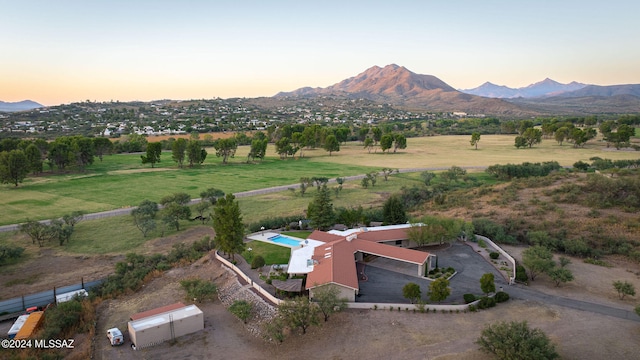 aerial view at dusk featuring a mountain view and a rural view