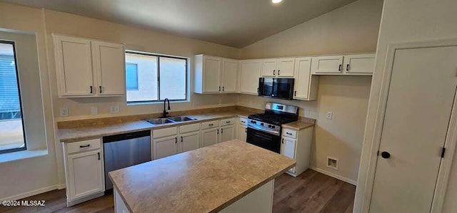 kitchen with lofted ceiling, a kitchen island, white cabinets, and stainless steel appliances