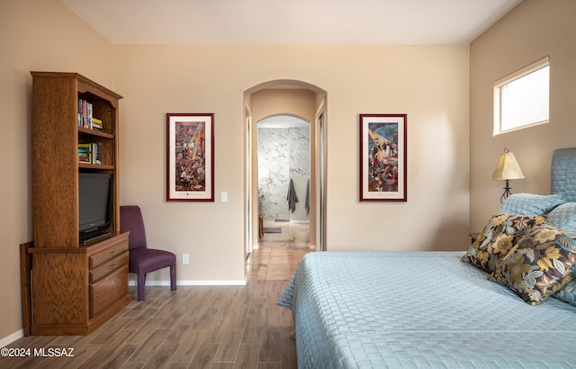 bedroom featuring hardwood / wood-style floors and ensuite bath