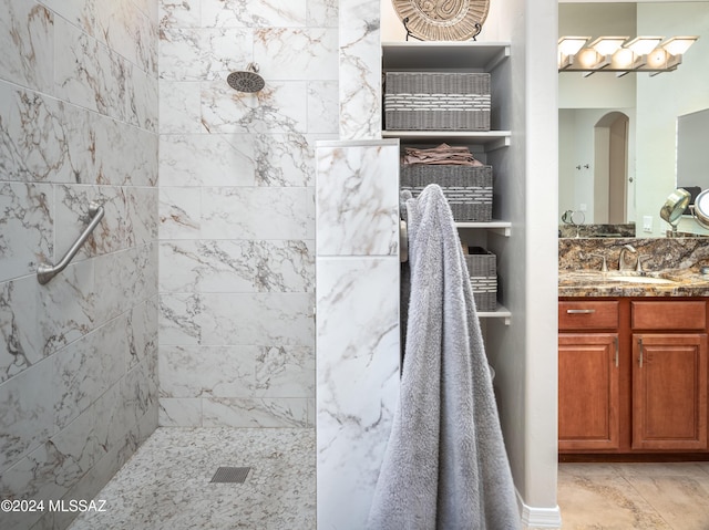 bathroom with vanity and a tile shower