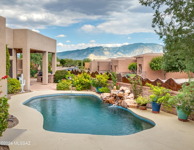 view of pool featuring a mountain view, a patio, and pool water feature