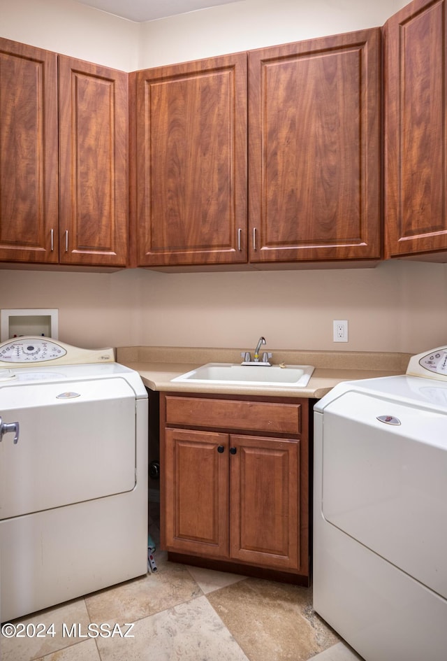 washroom with cabinets, sink, and washing machine and clothes dryer