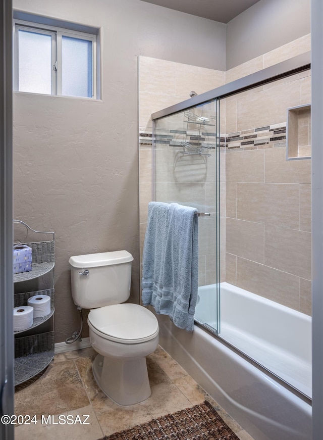 bathroom with shower / bath combination with glass door and toilet