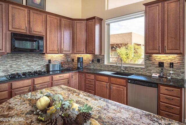 kitchen featuring dark stone counters, sink, decorative backsplash, and black appliances