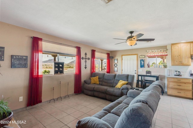 tiled living room with a textured ceiling and ceiling fan