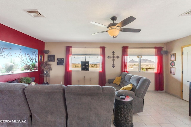 living room featuring ceiling fan, a mountain view, and light tile patterned floors