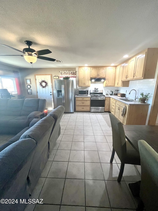 kitchen featuring appliances with stainless steel finishes, ceiling fan, sink, light brown cabinets, and light tile patterned floors