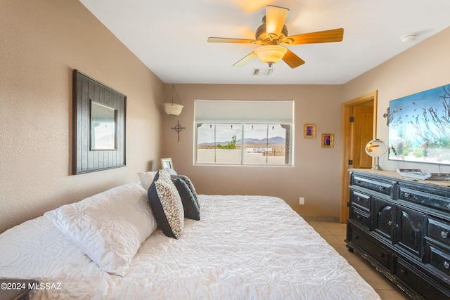 tiled bedroom with ceiling fan