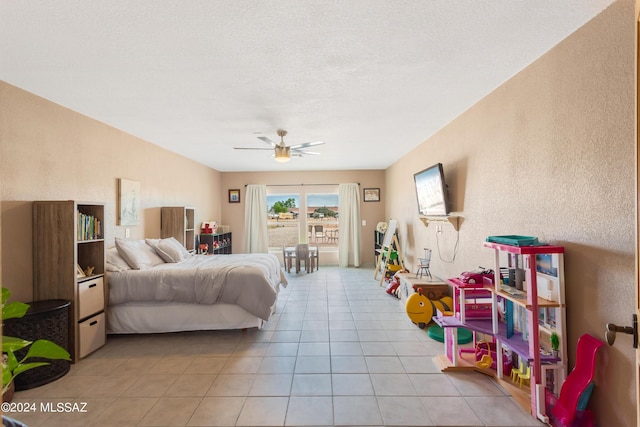 tiled bedroom featuring ceiling fan and a textured ceiling