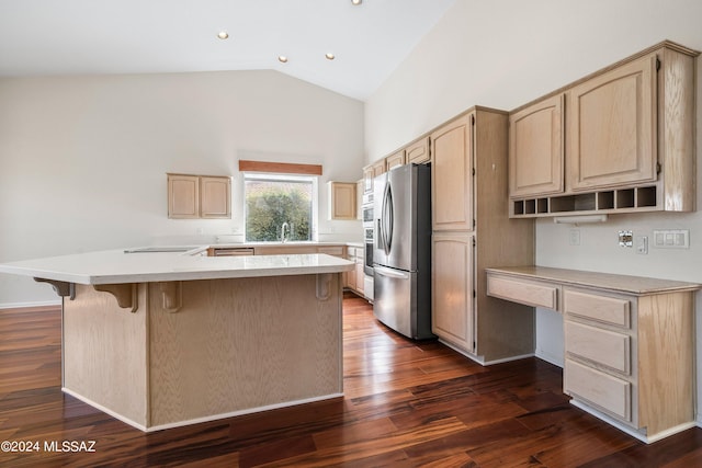 kitchen featuring light brown cabinets, appliances with stainless steel finishes, dark wood-type flooring, and lofted ceiling