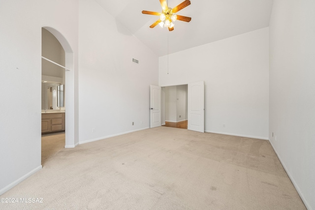 unfurnished room with ceiling fan, light carpet, and high vaulted ceiling