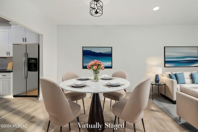 dining space with an inviting chandelier and light wood-type flooring