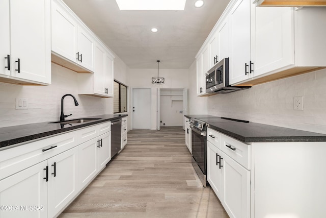 kitchen featuring white cabinetry, sink, appliances with stainless steel finishes, and light wood-type flooring