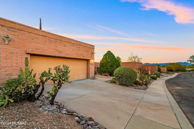 view of garage at dusk