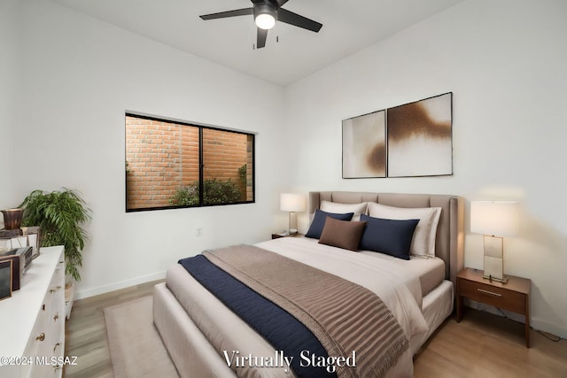 bedroom with light hardwood / wood-style floors and ceiling fan