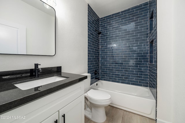 full bathroom featuring hardwood / wood-style flooring, vanity, toilet, and tiled shower / bath