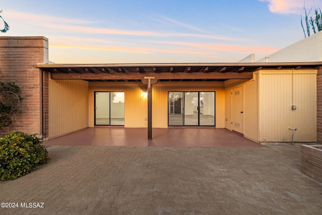 back house at dusk with a patio