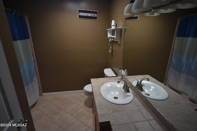 bathroom featuring toilet, sink, and curtained shower