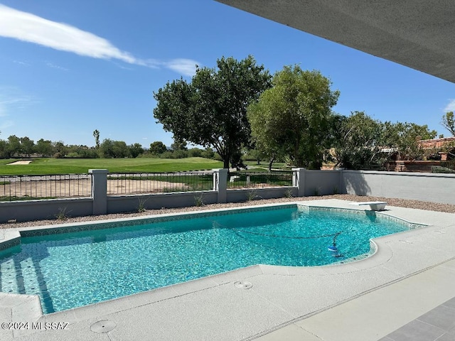 view of swimming pool with a diving board