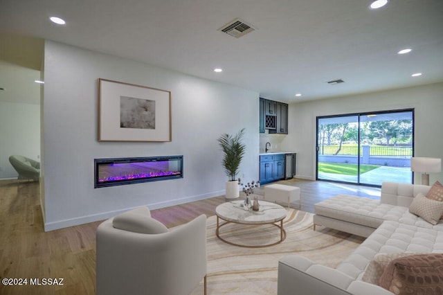 living room with light hardwood / wood-style floors and sink