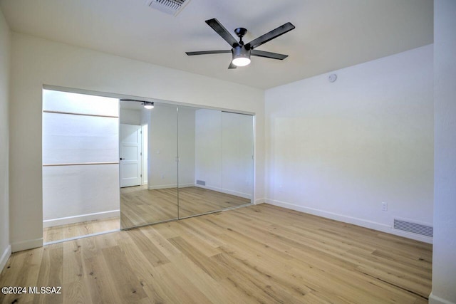 unfurnished bedroom featuring ceiling fan, a closet, and light wood-type flooring