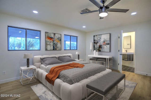 bedroom with hardwood / wood-style floors, ensuite bath, and ceiling fan