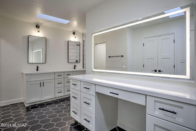 bathroom with tile patterned flooring, vanity, and a skylight