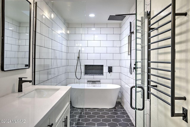 bathroom with radiator, tile patterned floors, vanity, independent shower and bath, and tile walls