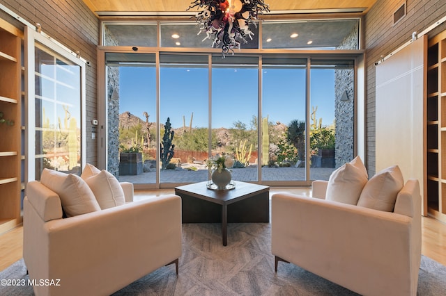 sunroom with a chandelier and wooden ceiling