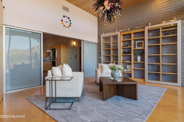 living area featuring high vaulted ceiling, wood ceiling, and hardwood / wood-style floors