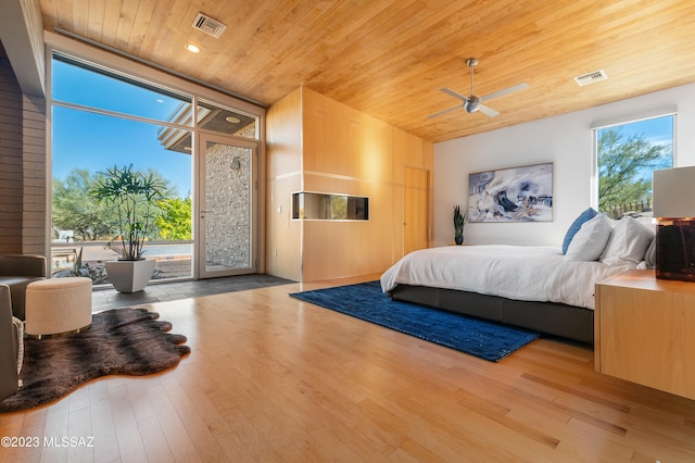 bedroom with access to outside, light wood-type flooring, and wood ceiling