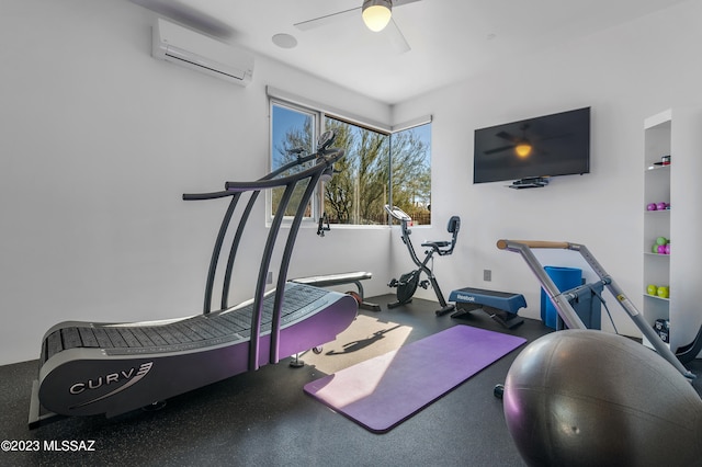 exercise room featuring a wall unit AC and ceiling fan