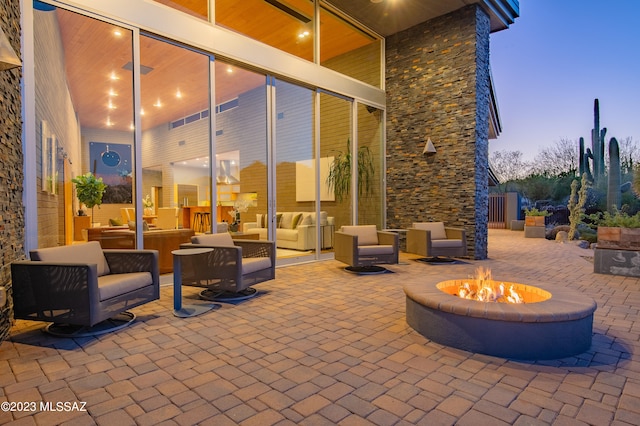 patio terrace at dusk featuring an outdoor fire pit