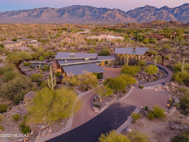 aerial view at dusk featuring a mountain view