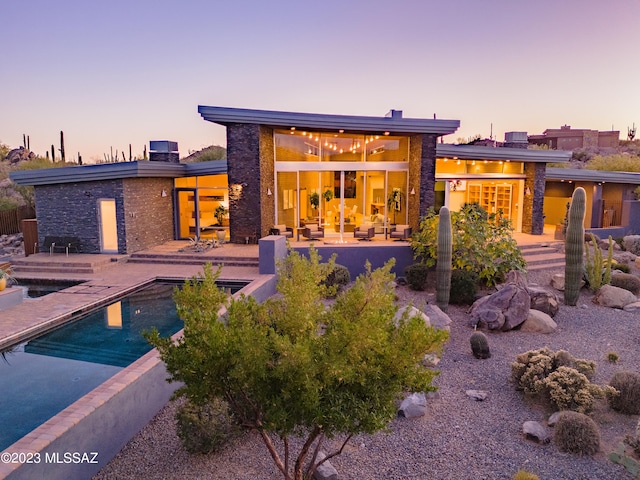 back house at dusk with a patio