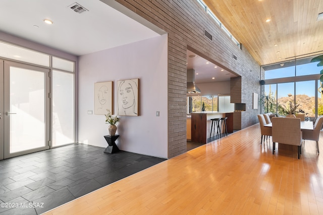 dining room featuring wood ceiling, brick wall, dark hardwood / wood-style floors, and expansive windows