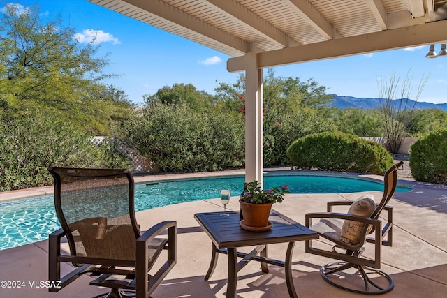 view of pool featuring a patio area and a mountain view