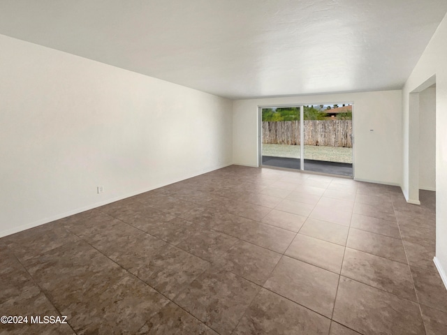 spare room with dark tile patterned floors